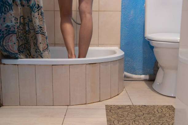 young girl in the shower at home, bath mat in the shower at home