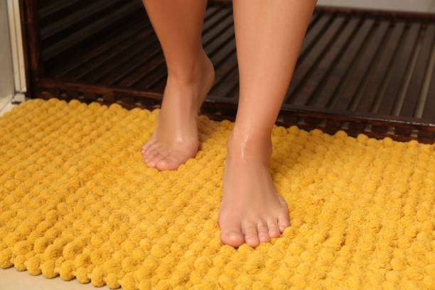 Woman standing on bath mat