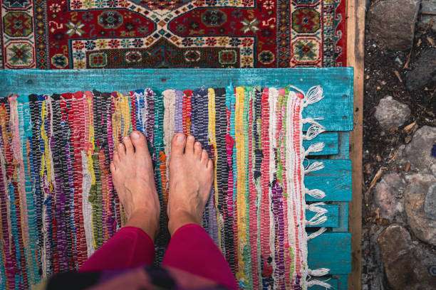 Bare feet standing on bath mat