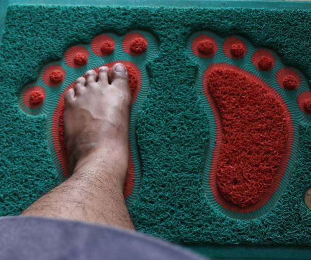 a man's feet on a brown bath mat