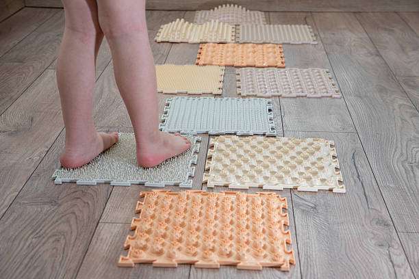 Child's feet stand on an orthopedic bath mat