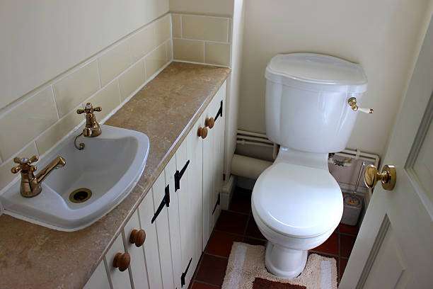 Small white bath mat next to toilet and sink.
