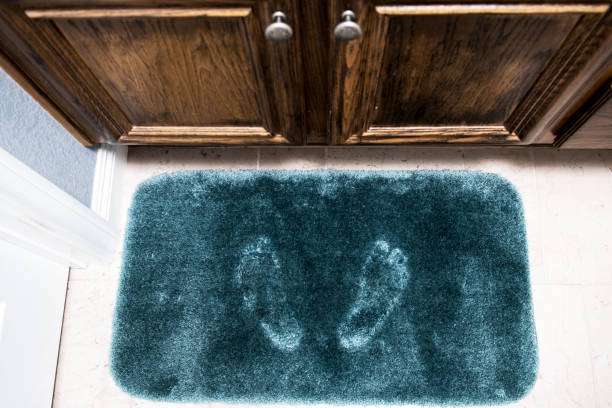 green bath mat with footprints. Bathroom scene