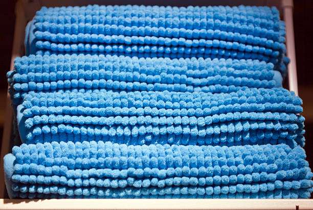 Stack of plush blue bath mats.