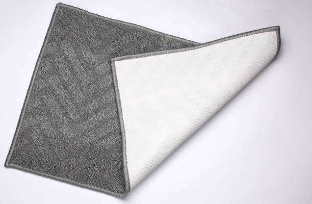 Gray bath mat folded, showing non-slip backing.